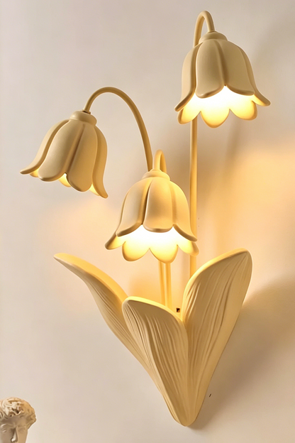 Close-up of lit floral wall lamp showing warm glow | Metal, Resin |