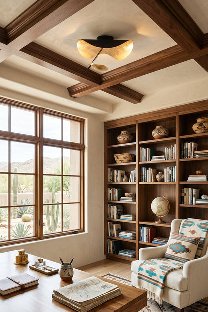 Gold-Tone Sculptural Ceiling Light illuminating a cozy reading nook with a wooden bookshelf and window.