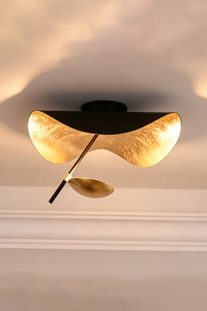 Gold-Tone Sculptural Ceiling Light featuring wave-like design and matte black canopy.