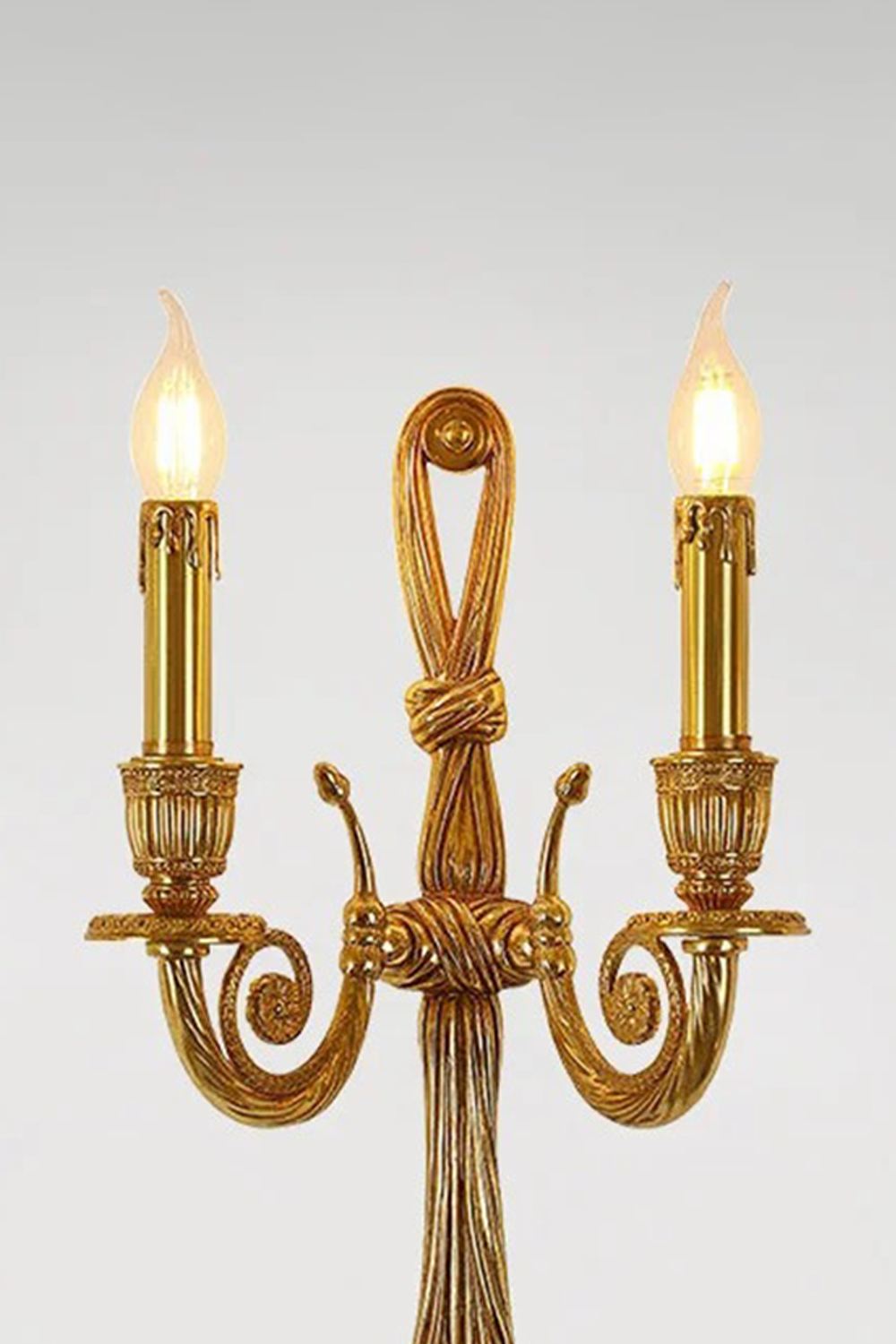 Honoria Rope and Tassel Brass Sconce | Brass and Metal | Full front illuminated view displayed against a solid light grey background | vexa lamps