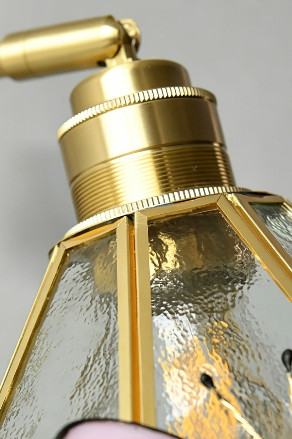 Iris Butterfly Stained Glass Wall Lamp | Stained Glass, Metal, Wood | Macro close-up view of the polished gold brass socket cap, adjustable joint hardware, and the upper edge of the textured clear hammered glass shade | Detail shot | vexa lamps