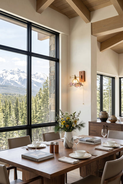 Iris Butterfly Stained Glass Wall Lamp | Stained Glass, Metal, Wood | Installed on a wooden wall in an alpine-style dining room, casting a warm glow next to a long dining table and large grid windows overlooking mountains | vexa lamps