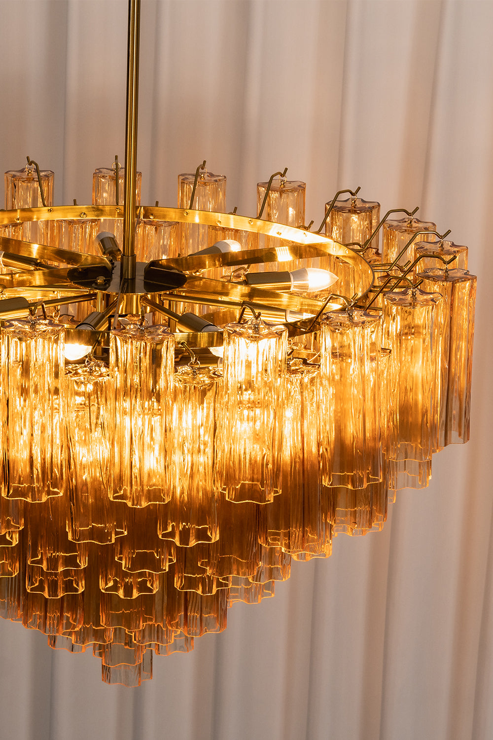 Isadora Tiered Amber Glass Chandelier showcasing amber glass prisms and warm lighting in an elegant design.