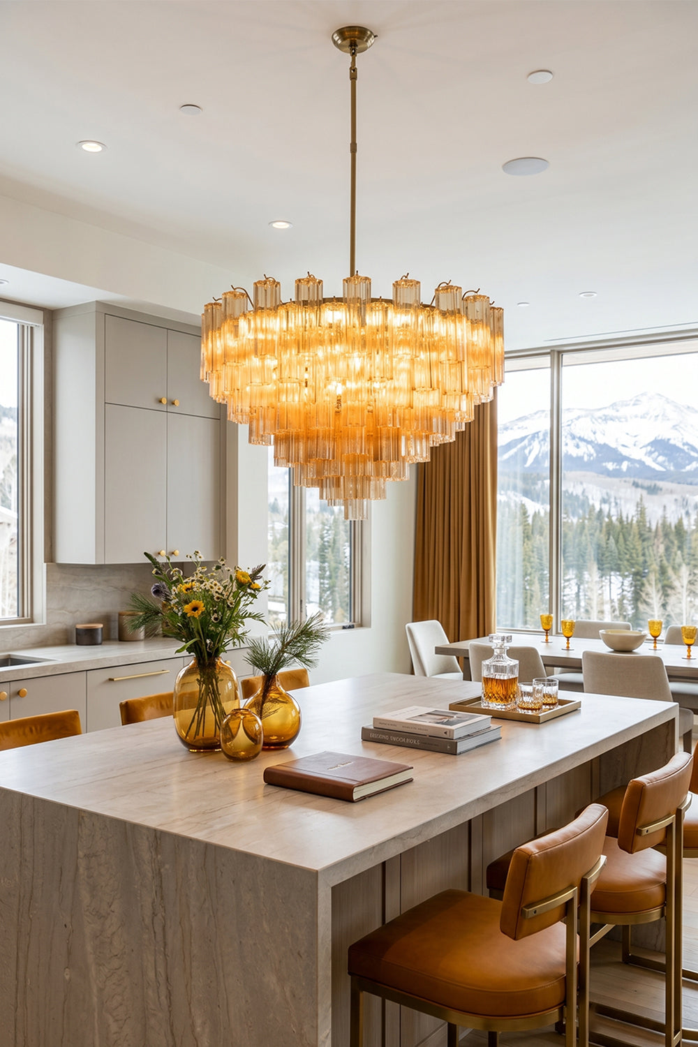 Isadora Tiered Amber Glass Chandelier illuminating a modern kitchen with mountain views.