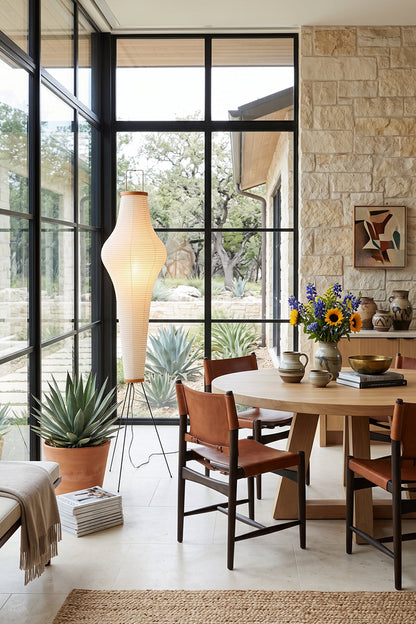 Isolde Ribbed Paper Column Floor Lamp in stylish dining area with natural light and plants.