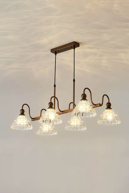 Isolde Vintage Glass Long Chandelier | Warm Halo Effect | Staged studio shot of the illuminated linear glass chandelier projecting a beautiful golden light pattern onto a warm cream ceiling | vexa lamps
