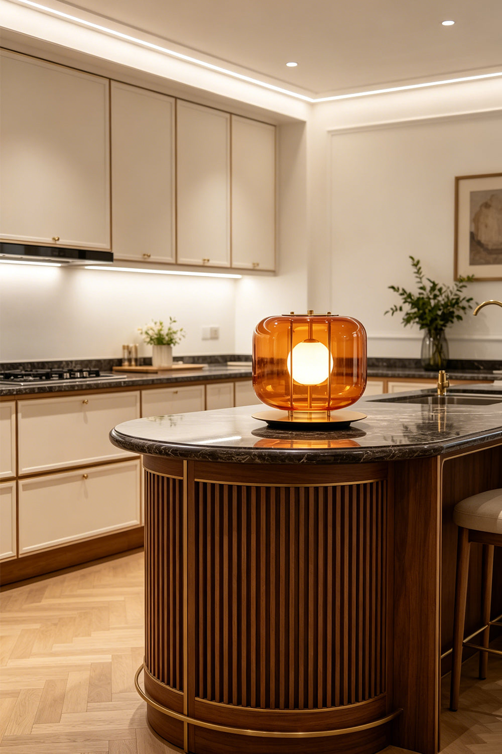 Jasper Colorblock Table Lamp | Glass, Metal | Amber orange glass block lamp lit elegantly on a fluted dark wood kitchen island counter with a polished black marble countertop | vexa lamps