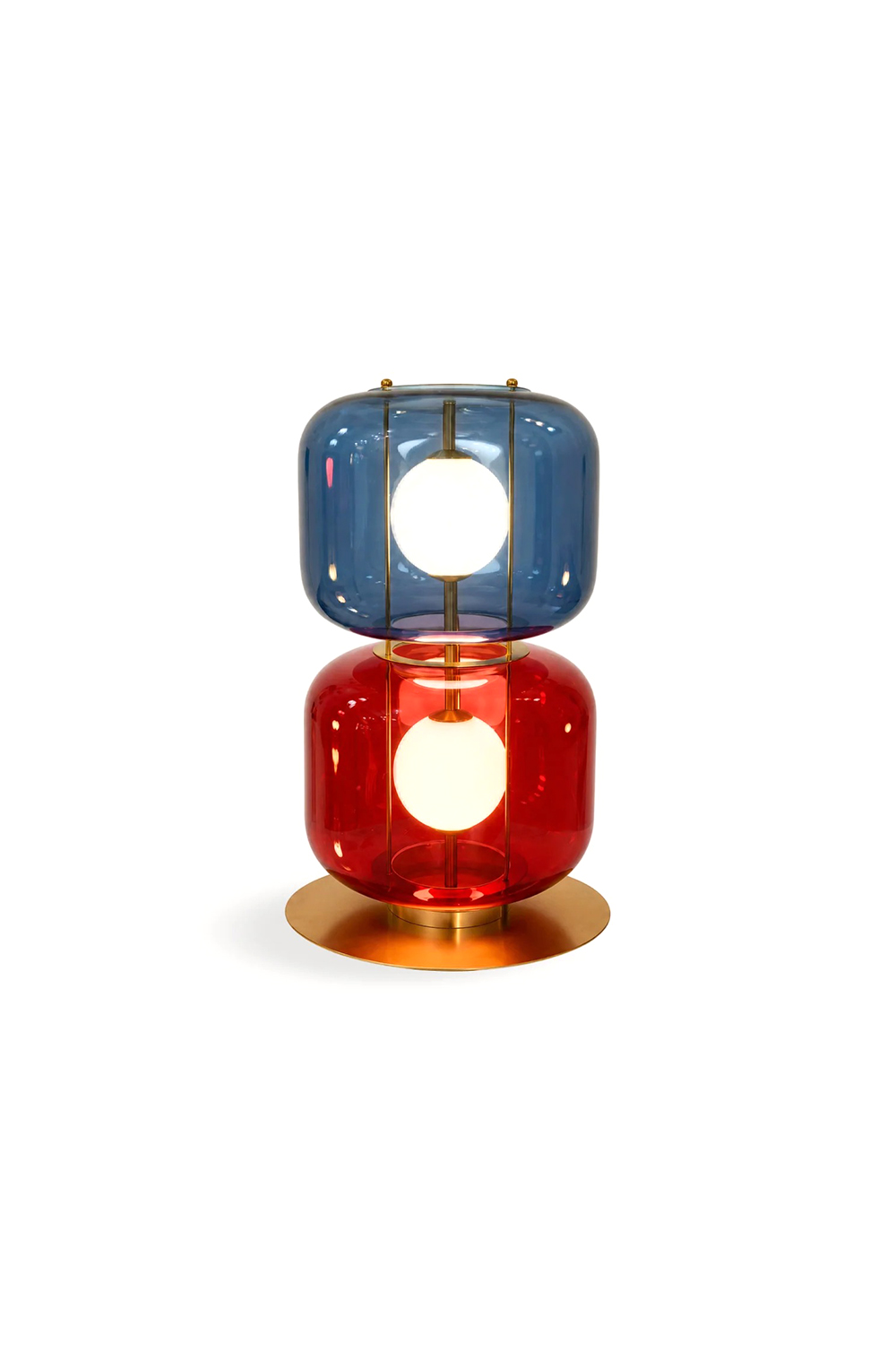 Jasper Colorblock Table Lamp | Glass, Metal | Isolated lit product view of a modern stacked color-block table lamp featuring a top blue glass module and a bottom red glass module on a gold brass base, each enclosing a glowing white frosted globe | White background | vexa lamps