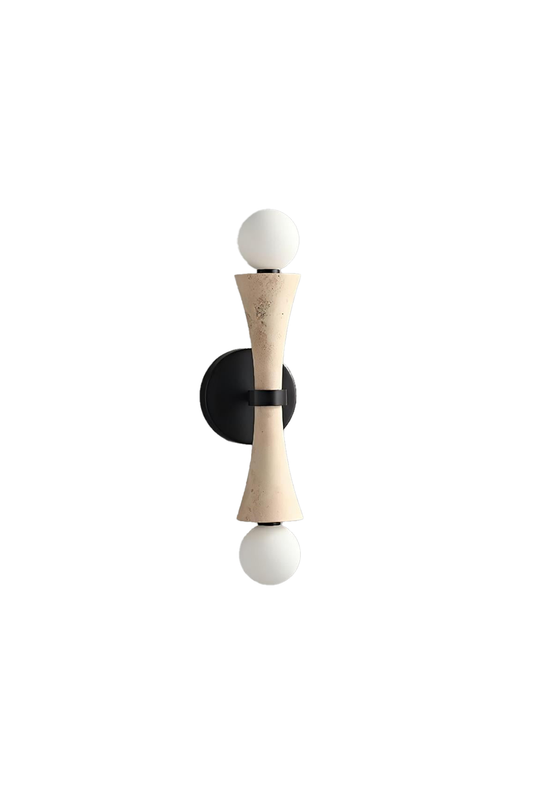 Katia Travertine Hourglass Wall Lamp | Travertine, Metal | Isolated unlit view of a modern architectural wall sconce featuring an hourglass-shaped natural beige travertine stone body and dual round glass globe bulbs on a black bracket | White background | vexa lamps