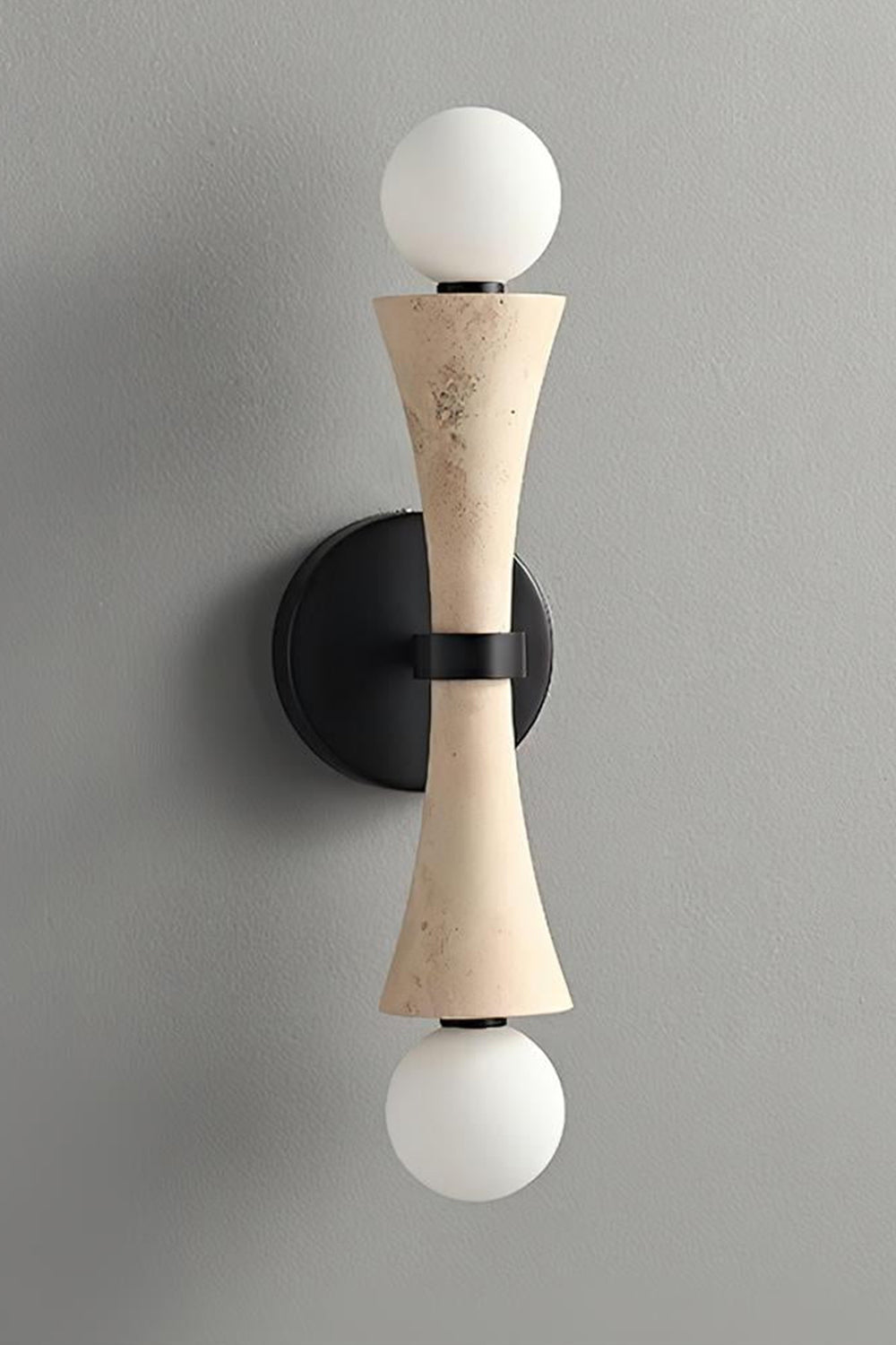 Katia Travertine Hourglass Wall Lamp | Travertine, Metal | Studio variant product view featuring the classic natural beige travertine stone hourglass body paired with black hardware | vexa lamps