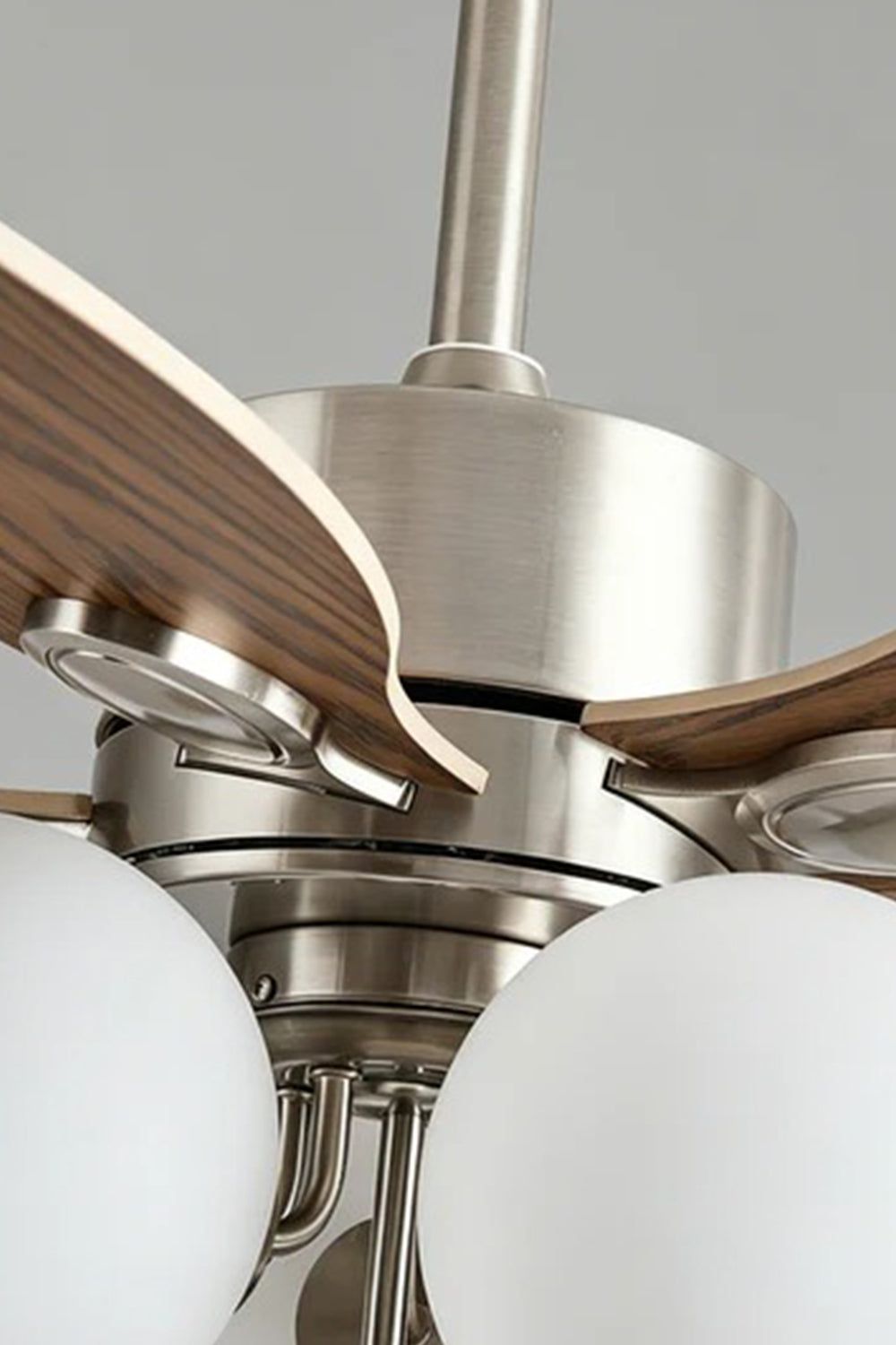 Keller Wooden Ceiling Fan Light | Wood, Glass, Metal | Detailed close-up shot focusing on the premium brushed silver metallic motor housing, dark wood blade connections, and white glass globes | Detail shot | vexa lamps
