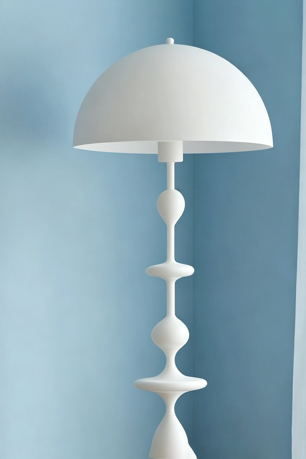 Kira Beaded Mushroom Floor Lamp | Metal, Glossy Finish | Close-up shot of the white mushroom dome shade and top beaded accents contrasted against a soft blue wall | vexa lamps