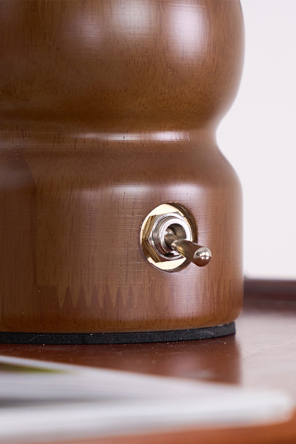 Kira Sculpted Mushroom Table Lamp | Wood, Glass | Detailed close-up showing the sleek metallic toggle switch embedded in the rich dark walnut wood base | Detail shot | vexa lamps