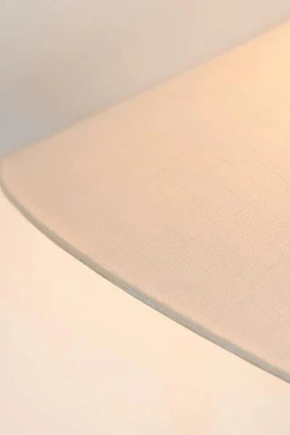 Lazuro Postmodern Cone Floor Light | Metal, Fabric | Detailed view from underneath the white linen cone lampshade showcasing the warm diffused glow and textured fabric weave | Detail shot | vexa lamps