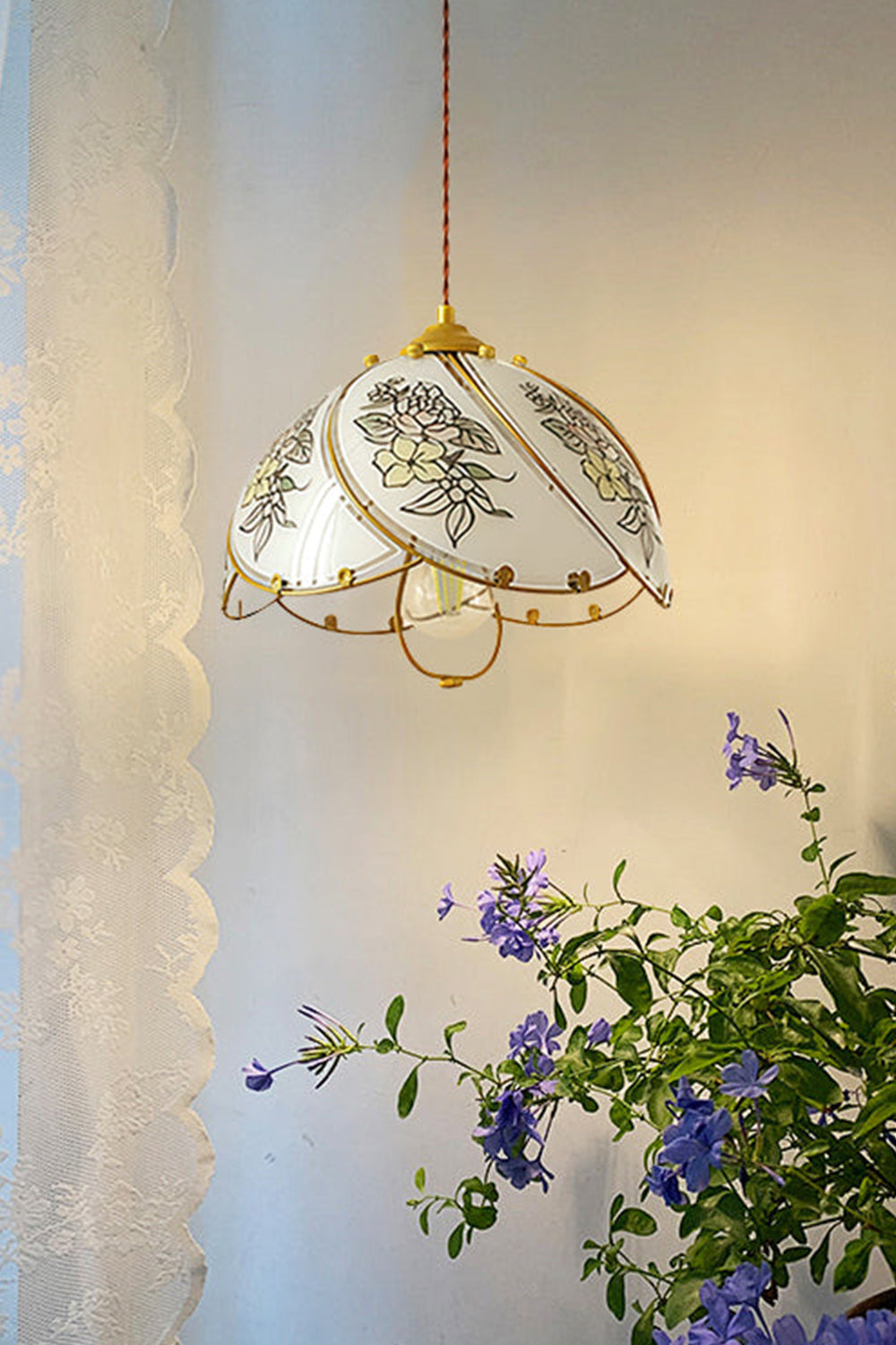 Lillian Retro Floral Pendant Lamp | Glass, Metal | Casting a warm amber glow next to a delicate white lace curtain with blooming purple flowers below | vexa lamps