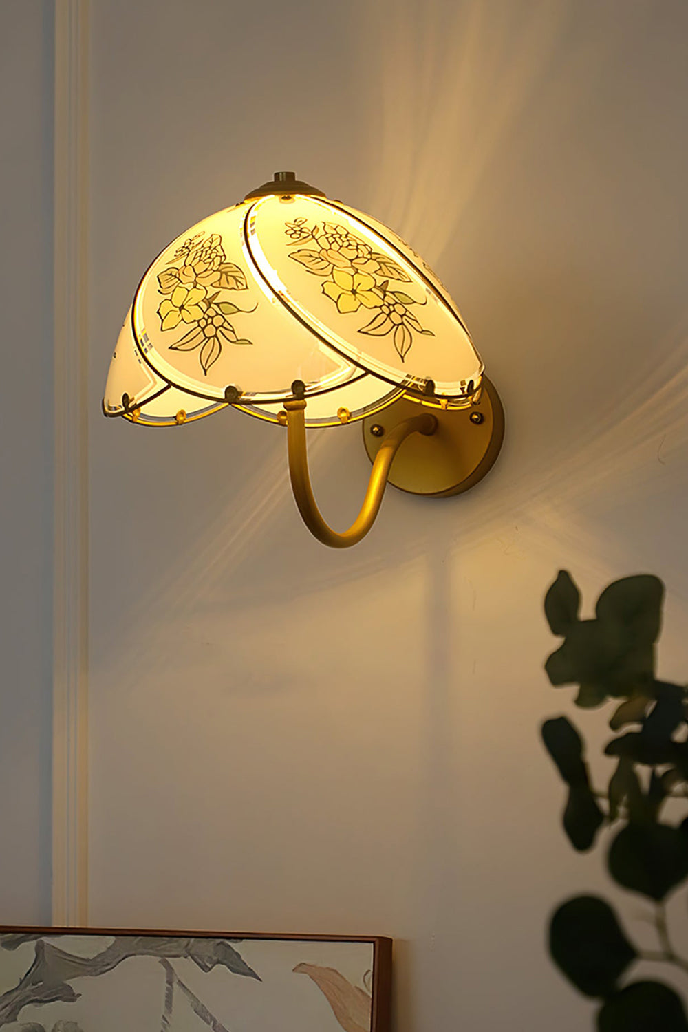 Lillian Retro Floral Wall Lamp | Glass, Metal | Close-up side profile view of the lit lamp radiating a warm golden glow on a wall in low light | vexa lamps