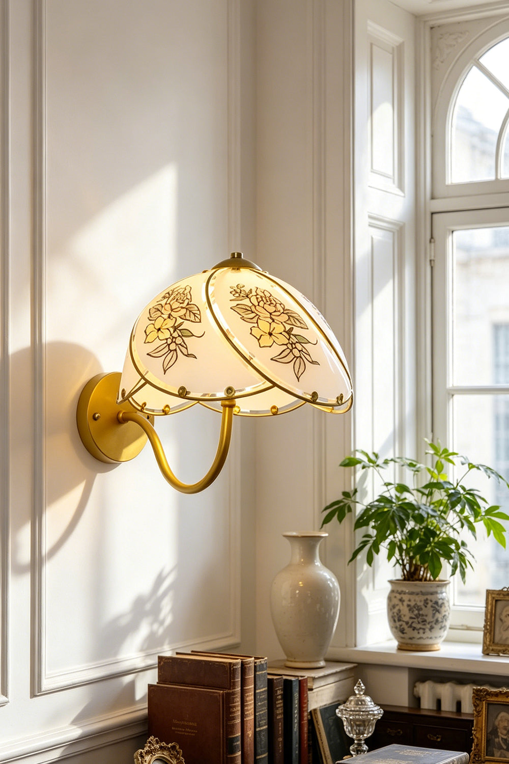Lillian Retro Floral Wall Lamp | Glass, Metal | Mounted next to a bright window over a wooden writing desk with books in a classic home study | vexa lamps
