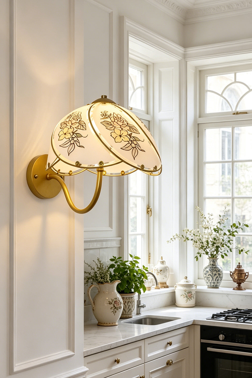 Lillian Retro Floral Wall Lamp | Glass, Metal | Mounted above a clean white kitchen countertop next to a window with potted plants | vexa lamps