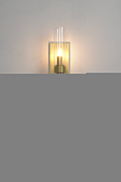 Linear metallic brass sconce lit | Brass, Glass | Positioned above a dark wooden cabinet | vexa lamps