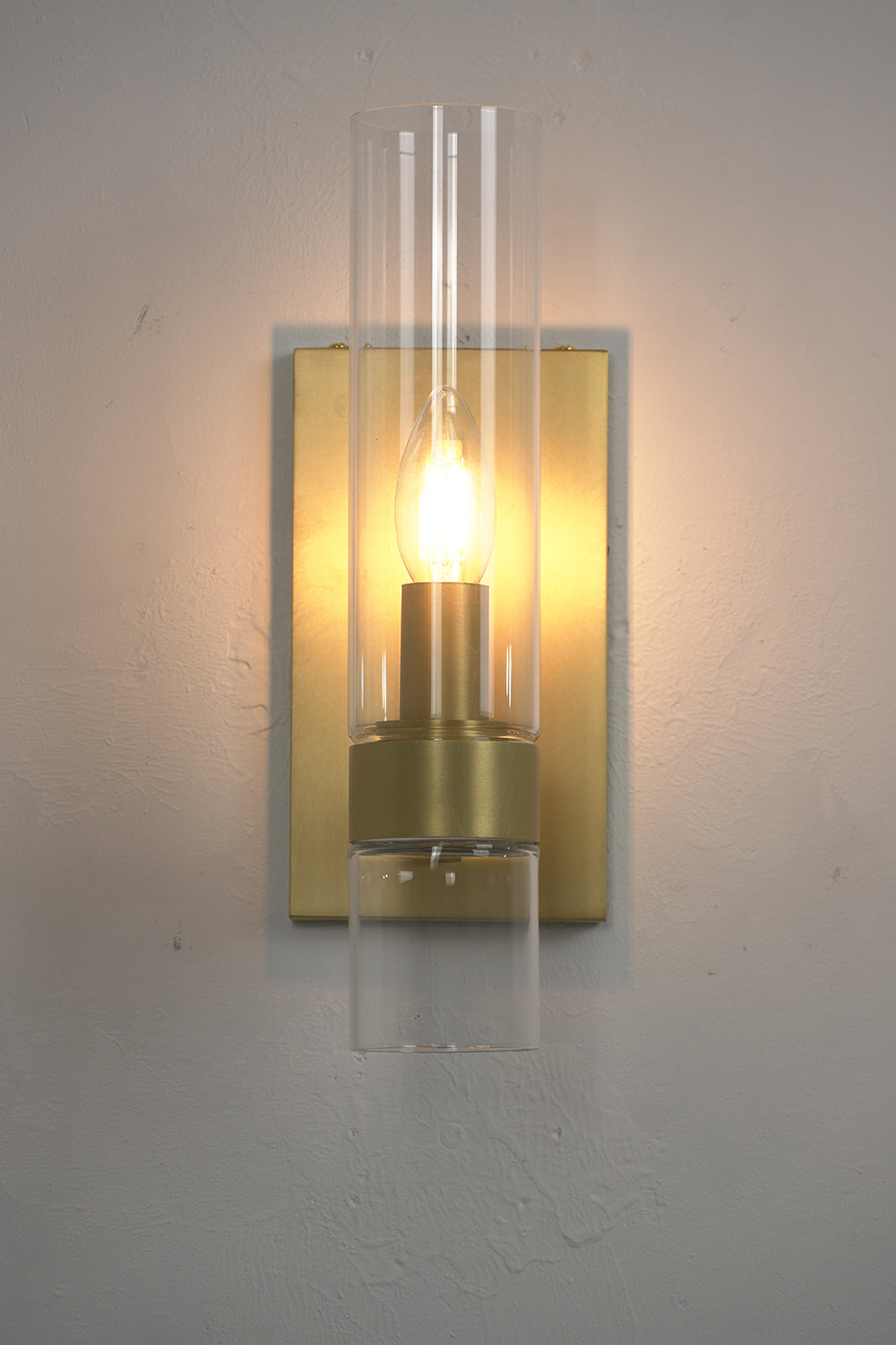 Front view of lit linear brass sconce | Brass, Glass | Close-up showing the candle bulb glow | vexa lamps