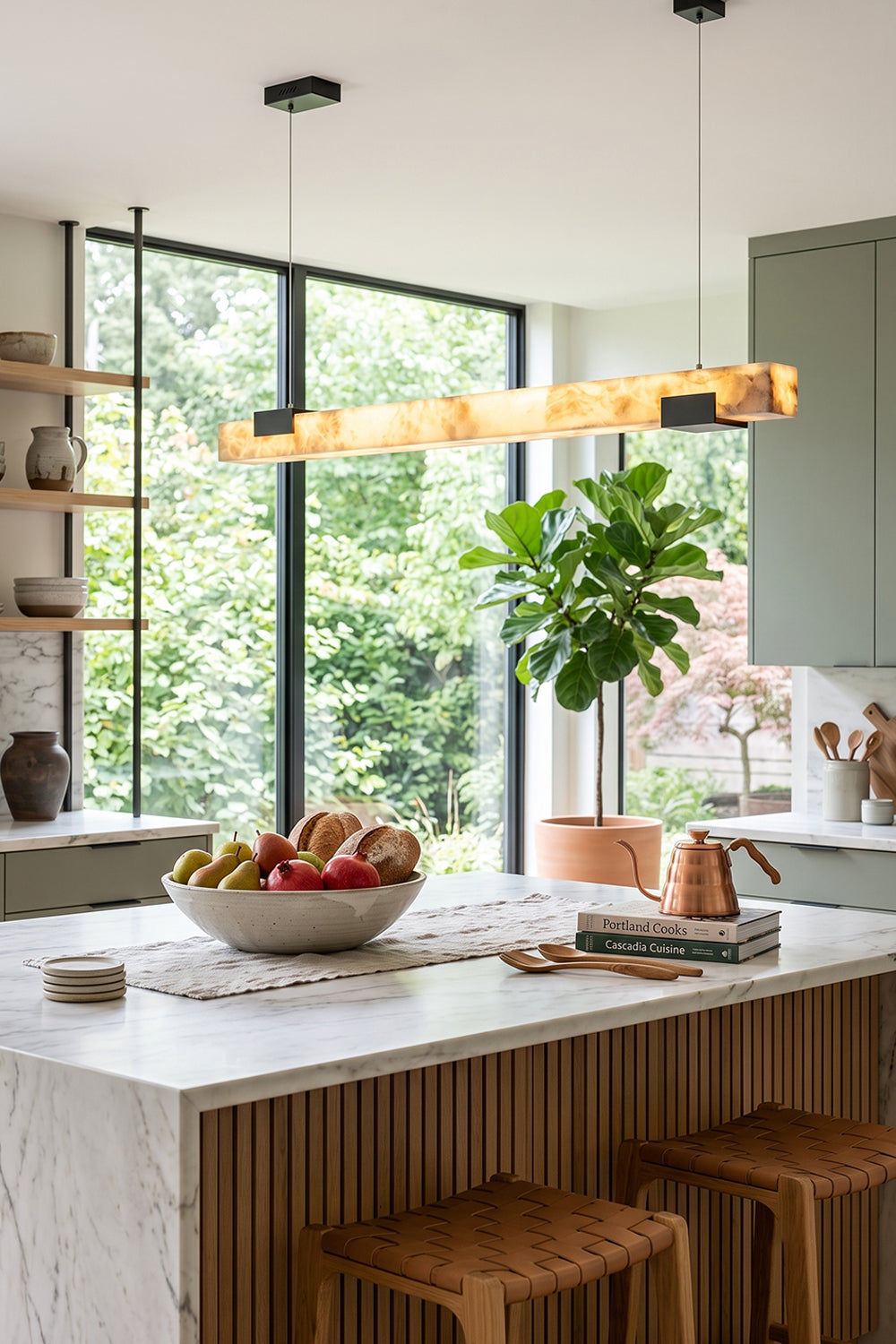 Liora Linear Alabaster Pendant Light | Natural Alabaster and Black Metal | Suspended over a kitchen island featuring a bowl of fresh fruits next to a bright window | vexa lamps