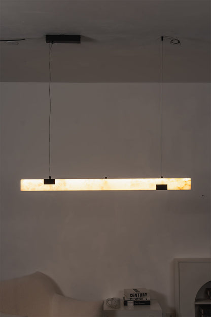Liora Linear Alabaster Pendant Light | Natural Alabaster and Black Metal | Straight front perspective of the glowing stone light fixture centered in a softly darkened room | Severn Lighting