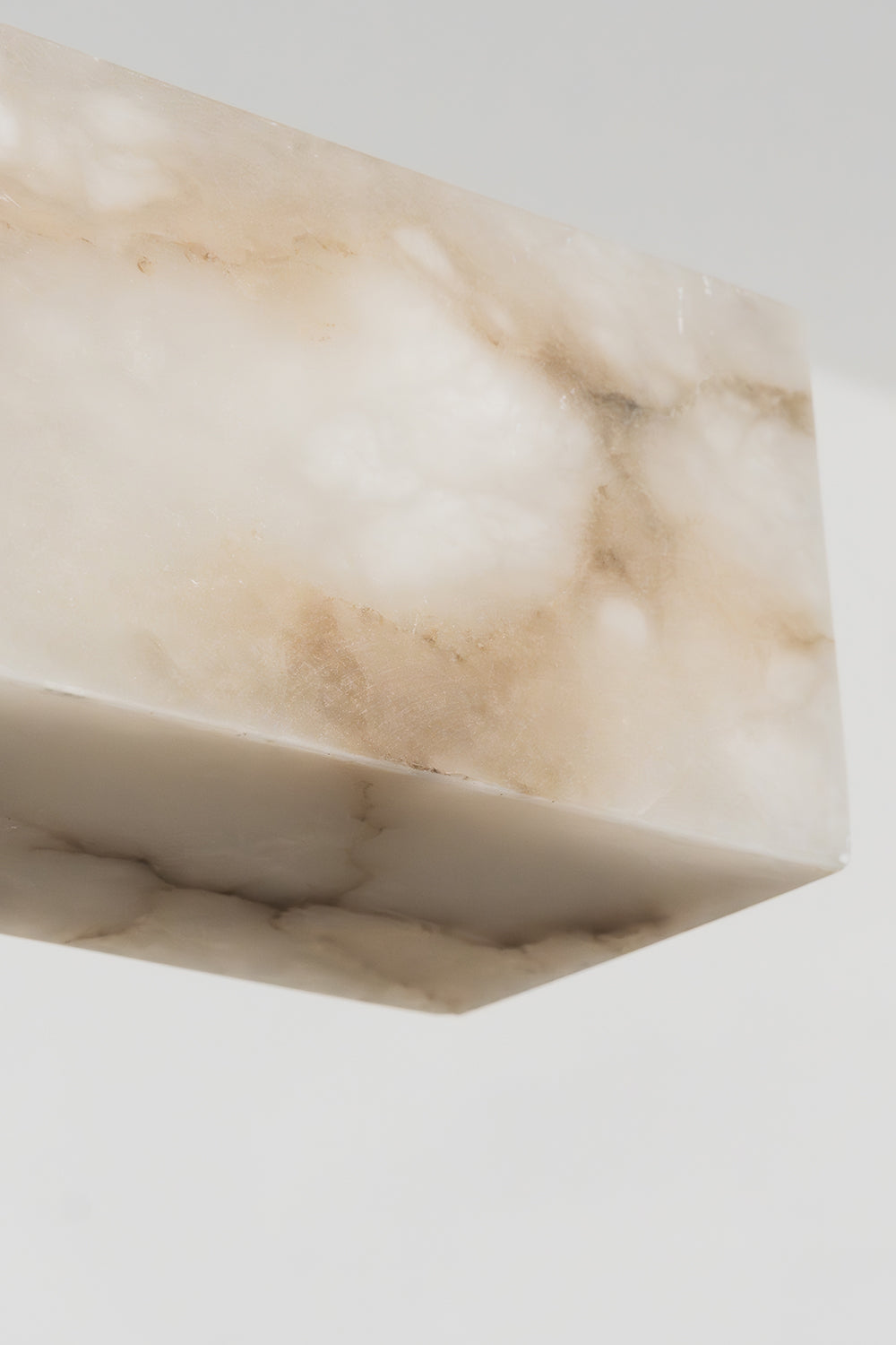 Liora Linear Alabaster Pendant Light | Natural Alabaster and Black Metal | Close-up view of the unlit white stone end profile showcasing its natural organic texture | vexa lamps