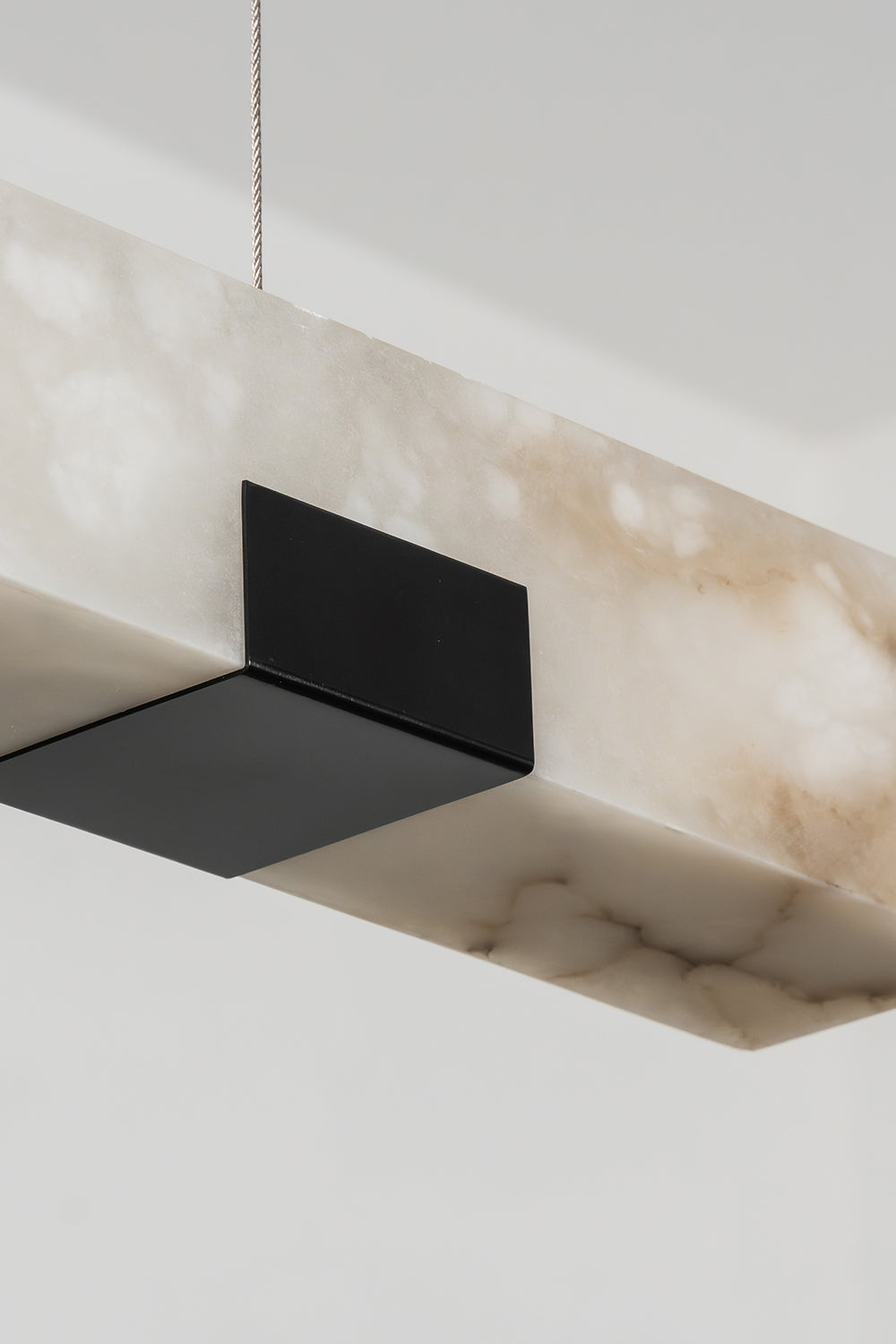 Liora Linear Alabaster Pendant Light | Natural Alabaster and Black Metal | Close-up view of the unlit linear block featuring the matte black metal support plate underneath | vexa lamps