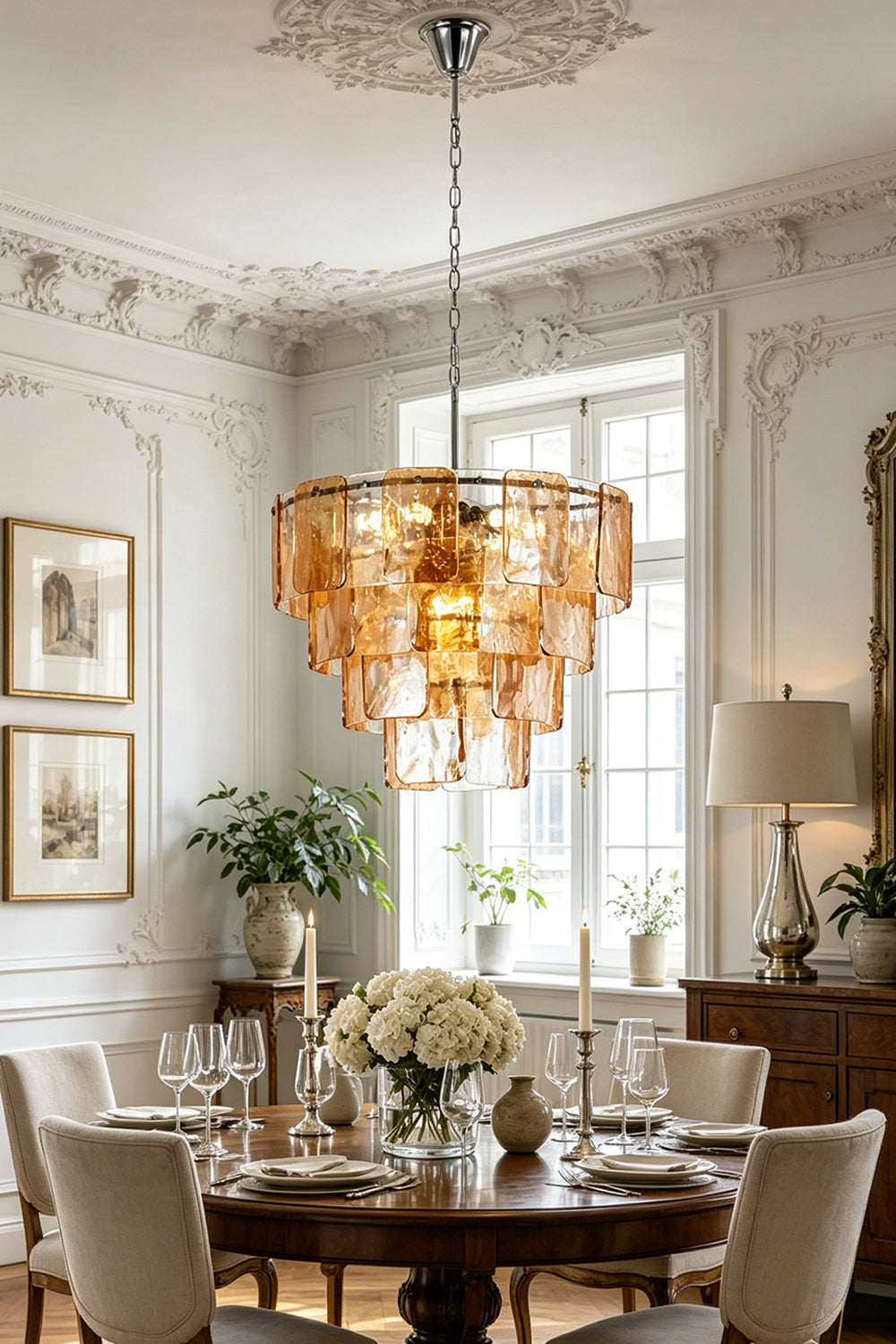 Lucia Tiered Amber Glass Chandelier | Glass, Metal | Suspended as an elegant statement centerpiece above a round dark wood dining table in a classical room with ornate wall moldings | vexa lamps