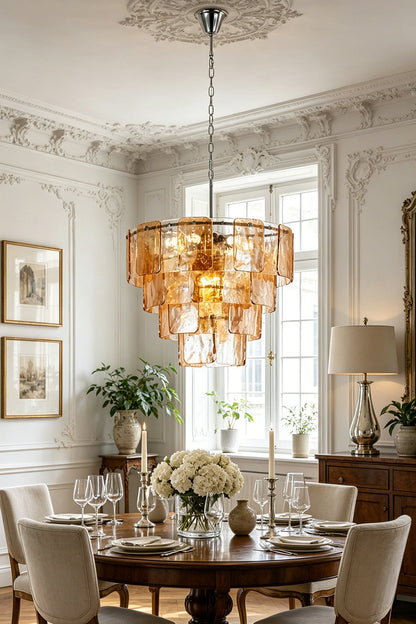Lucia Tiered Amber Glass Chandelier | Glass, Metal | Suspended as an elegant statement centerpiece above a round dark wood dining table in a classical room with ornate wall moldings | vexa lamps