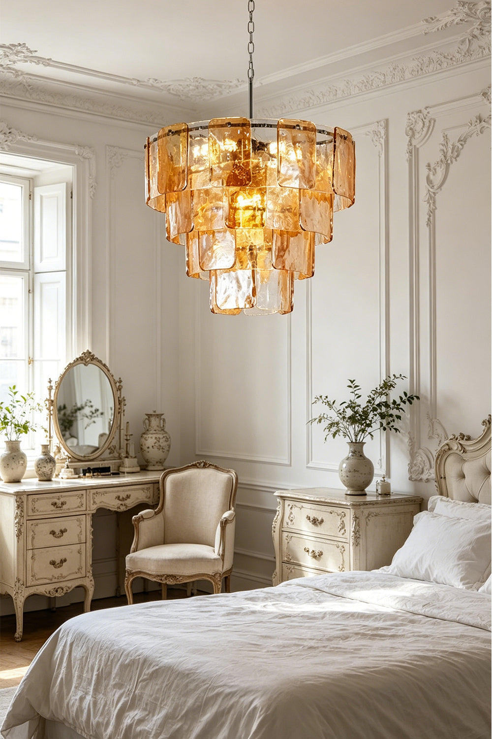 Lucia Tiered Amber Glass Chandelier | Glass, Metal | Providing a warm amber glow in a refined classical bedroom suite next to a vintage vanity table and white bedding | vexa lamps