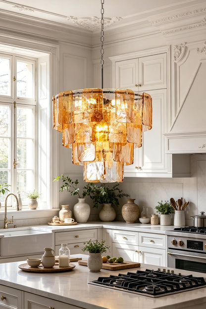 Lucia Tiered Amber Glass Chandelier | Glass, Metal | Positioned as luxury overhead statement lighting in a bright white kitchen above a marble island counter | vexa lamps