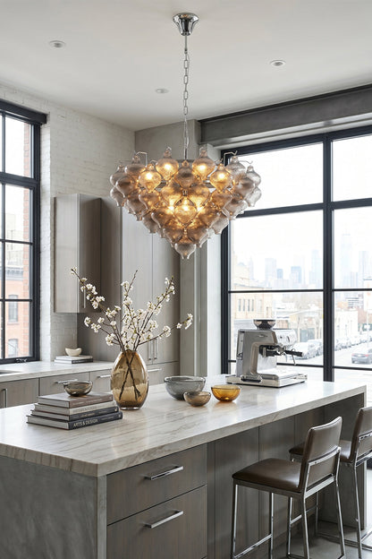 Lucina Tiered Smoked Glass Chandelier hanging in a modern kitchen, showcasing its hand-blown glass design and mid-century elegance.