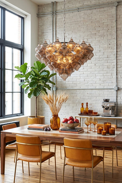 Lucina Tiered Smoked Glass Chandelier illuminating a modern dining space with a warm ambiance.