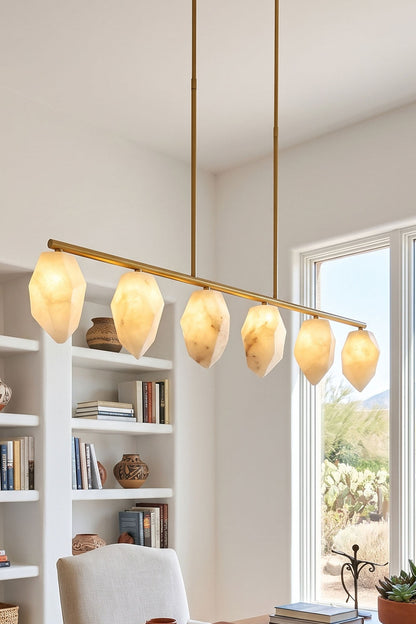 Manon Alabaster Drop Linear Chandelier | Natural Alabaster and Brass | Hanging in a bright study room over a table near white bookshelves | vexa lamps