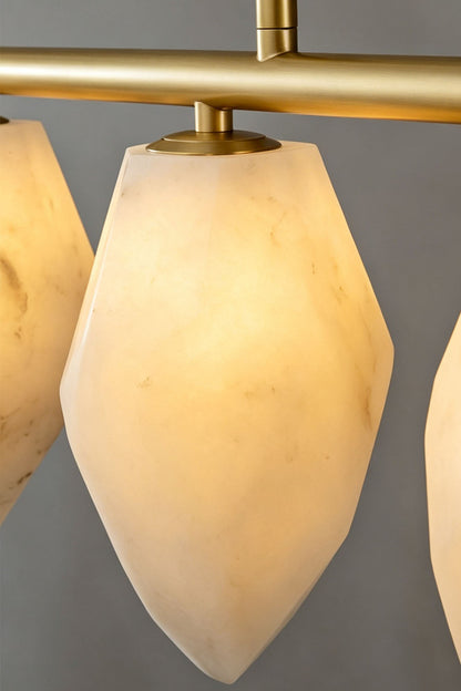 Manon Alabaster Drop Linear Chandelier | Natural Alabaster and Brass | Close-up detail of a single illuminated teardrop alabaster shade | vexa lamps