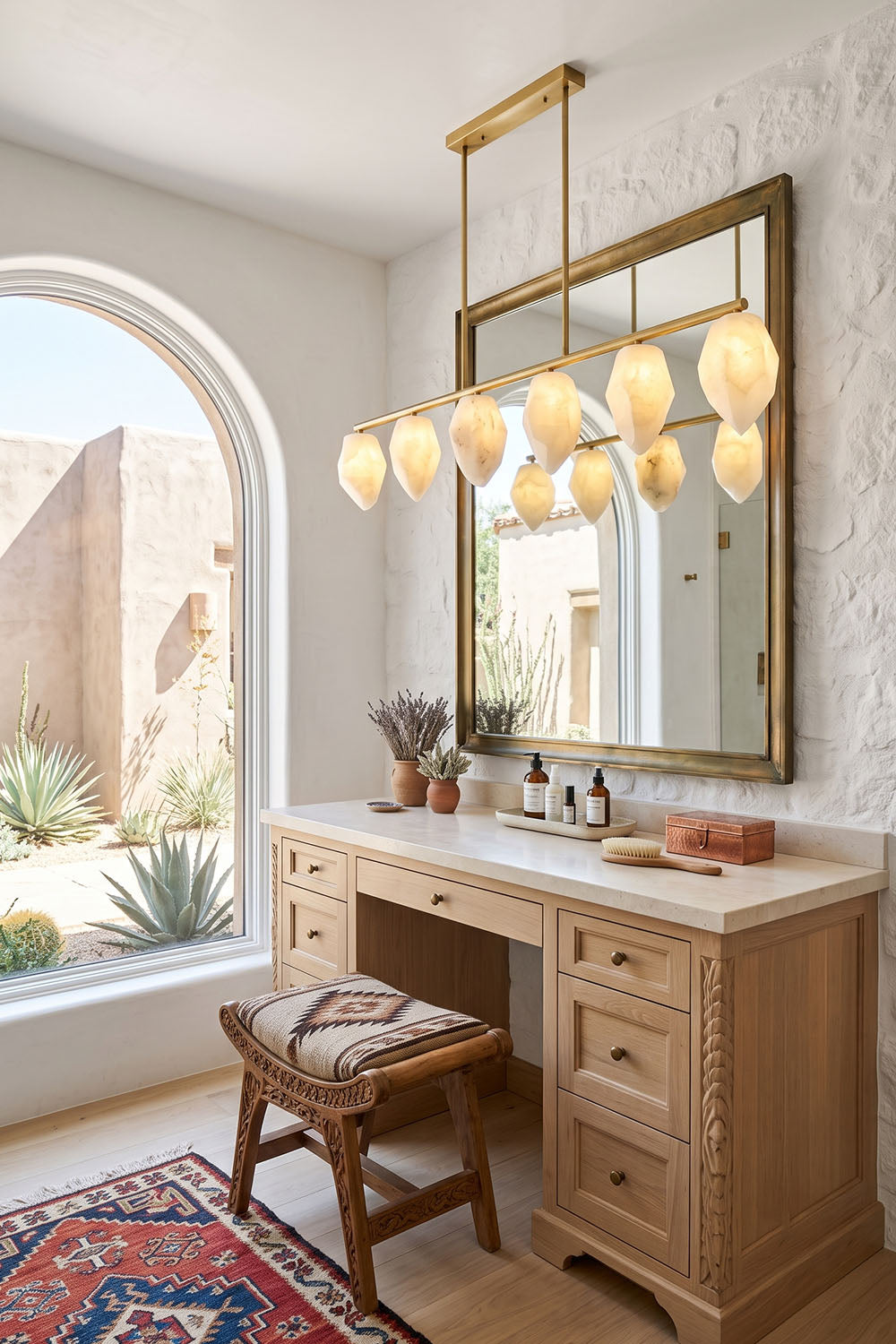 Manon Alabaster Drop Linear Chandelier | Natural Alabaster and Brass | Illuminating a wooden vanity desk in a bathroom with an arched window | vexa lamps