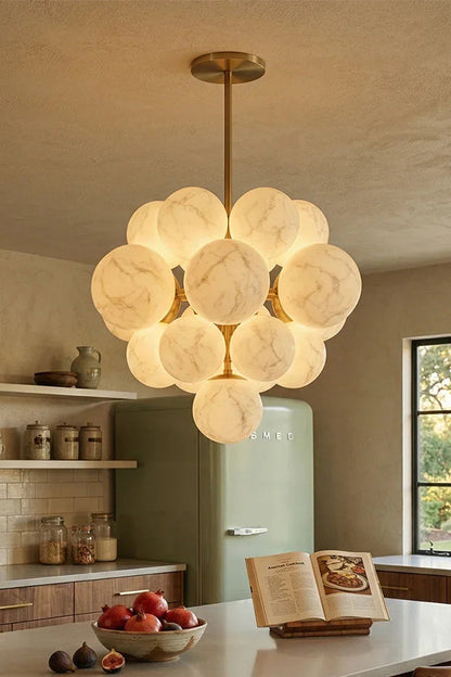 Marcella Alabaster Grape Cluster Chandelier illuminating a modern kitchen with warm, celestial glow.