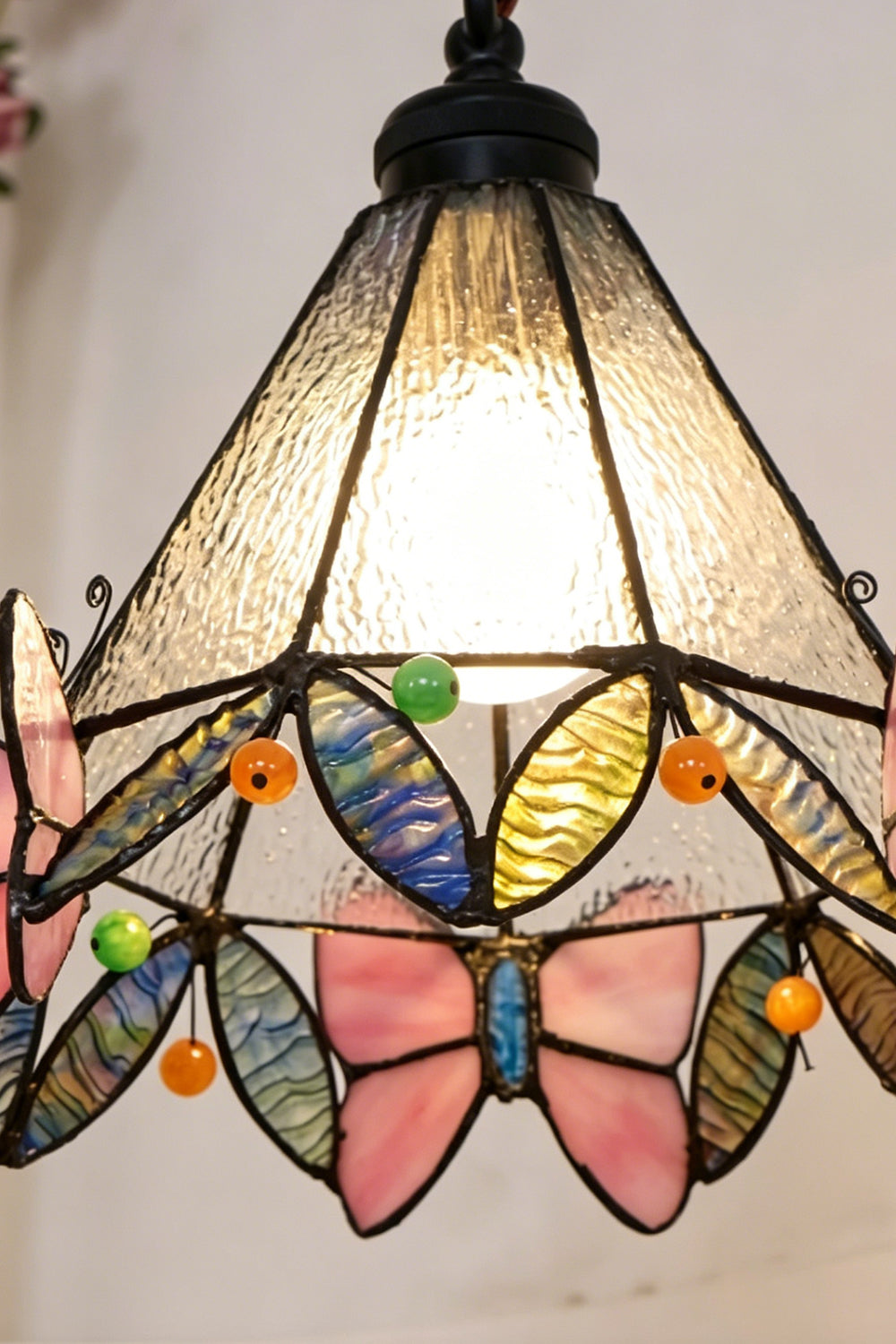 Mariposa Stained Glass Table Lamp | Glass, Metal | Detailed view of the fully illuminated Tiffany shade radiating a warm texture of mosaic art glass | Detail shot | vexa lamps