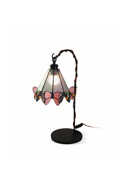 Mariposa Stained Glass Table Lamp | Glass, Metal | Elegant Tiffany-style stained glass desk lamp with pink butterfly motifs along the scalloped rim, hanging from a curved black metal arm | Isolated product shot on white background | vexa lamps
