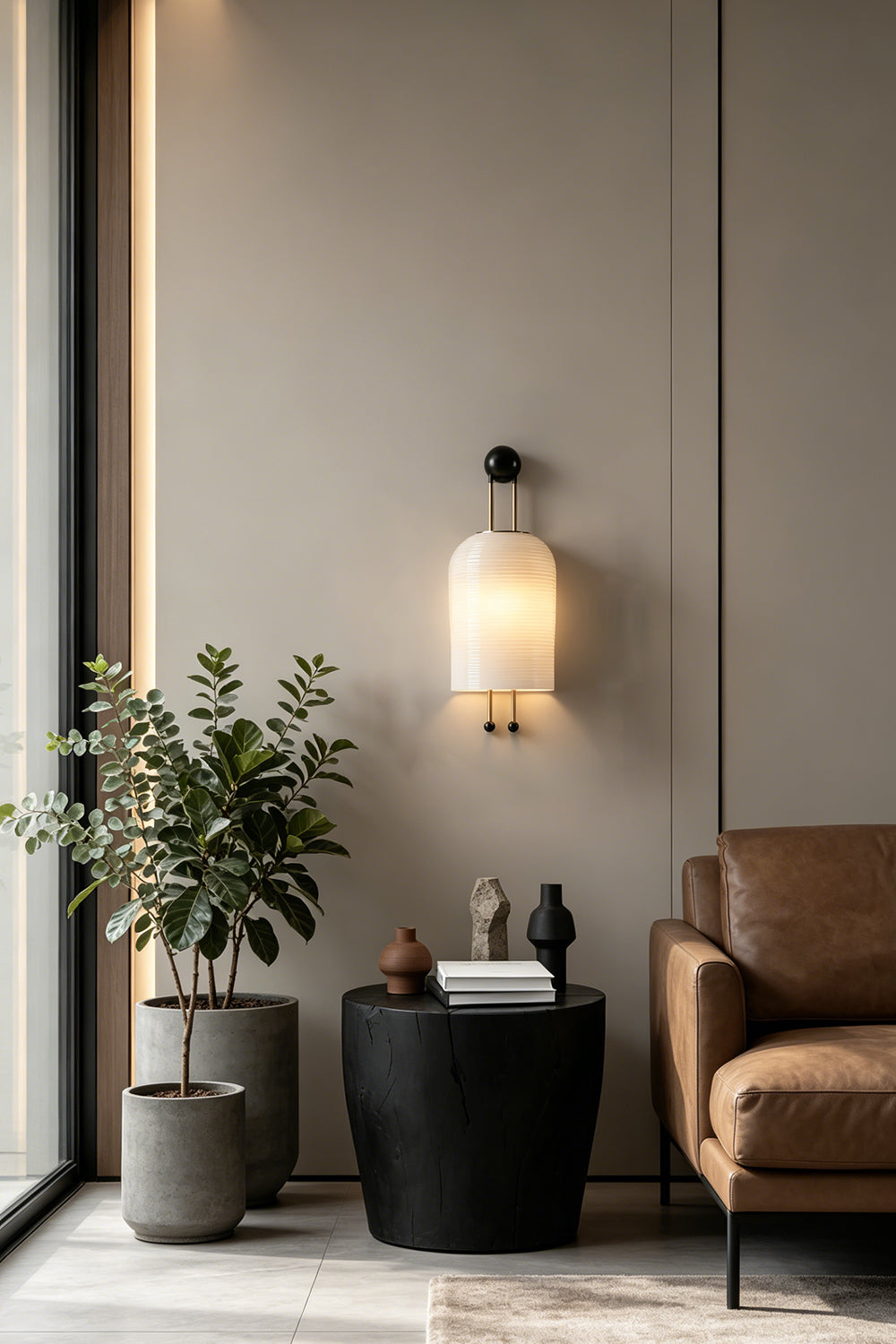 Marlow Linear Ribbed Glass Wall Lamp | Glass, Metal | Illuminating a contemporary lounge corner next to a sleek black side table and a large indoor potted plant | vexa lamps