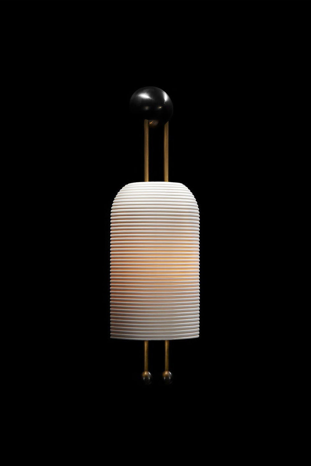 Marlow Linear Ribbed Glass Wall Lamp | Glass, Metal | Dramatic dark studio shot of the fully illuminated ribbed glass sconce glowing intensely against a solid black background | vexa lamps