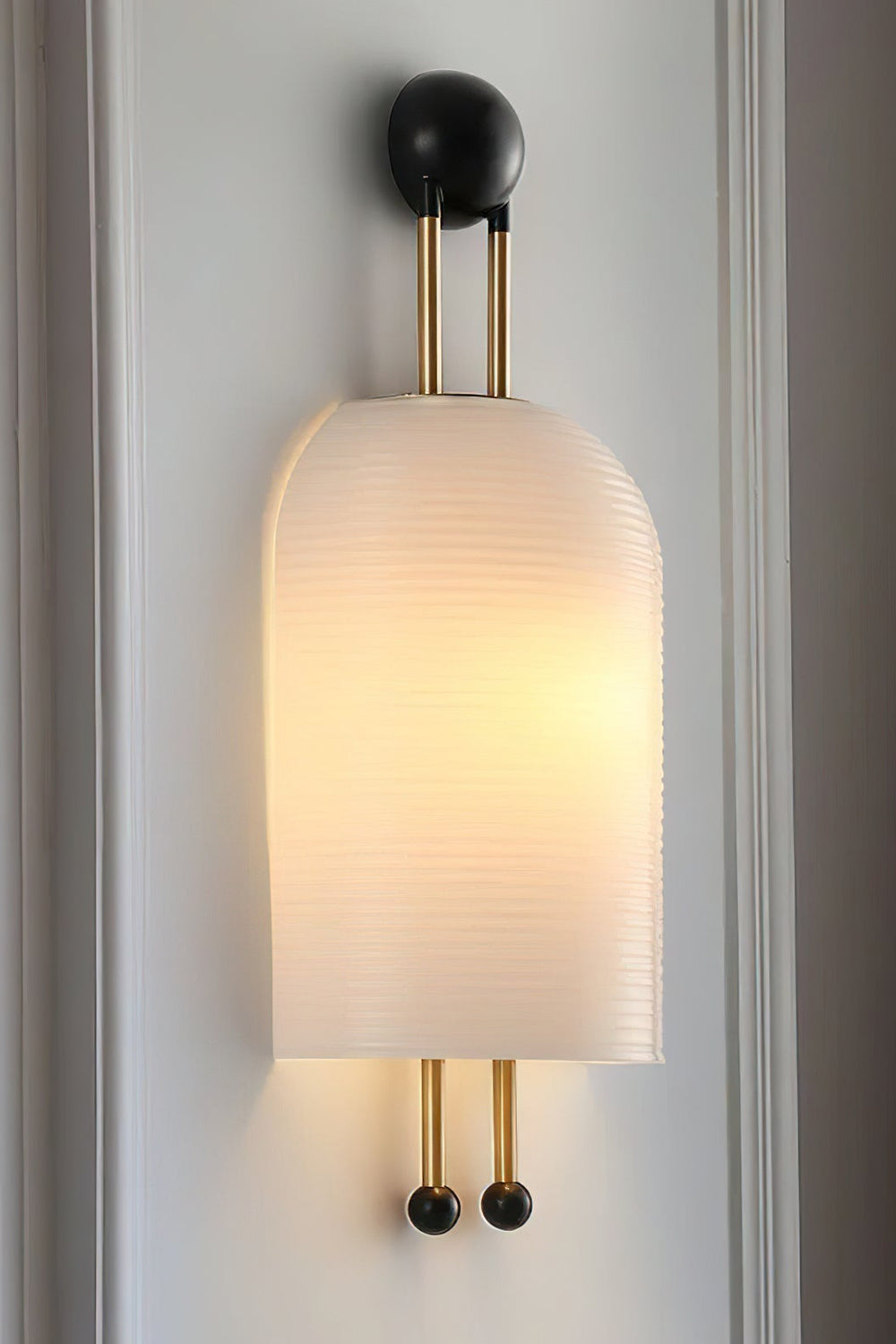 Marlow Linear Ribbed Glass Wall Lamp | Glass, Metal | Close-up focus on the illuminated diffused glass variant showcasing its clean seamless capsule silhouette and gold hardware | vexa lamps