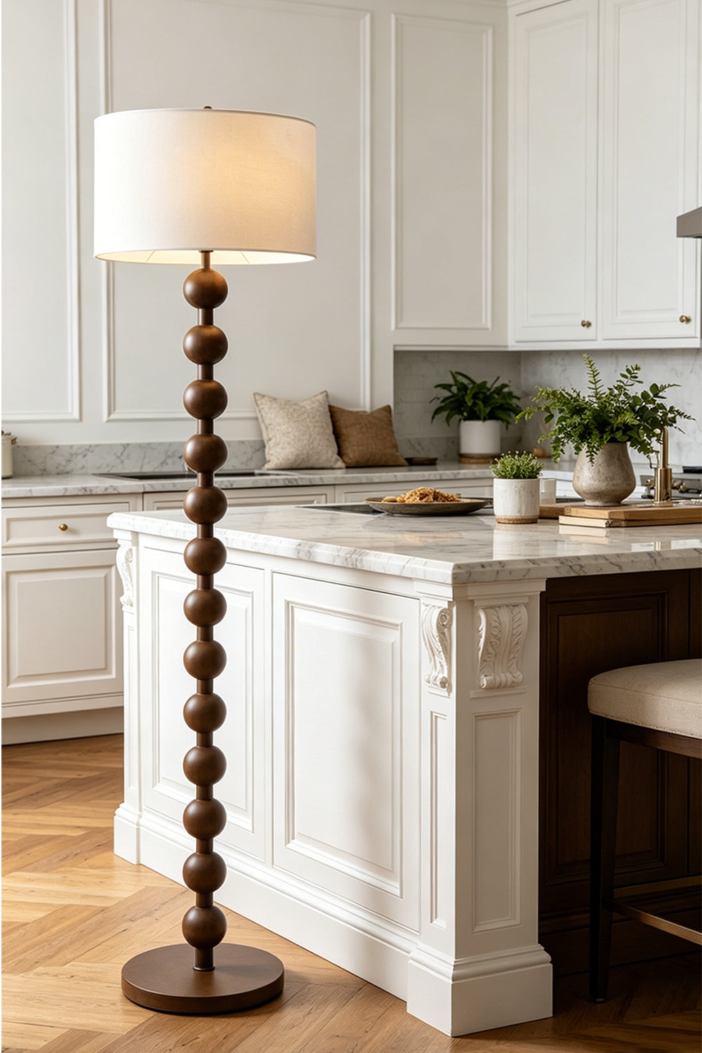 Marlow Stacked Wood Floor Lamp | Wood, Fabric | Standing gracefully in a bright classical kitchen space next to a white island counter with wooden bar stools | vexa lamps