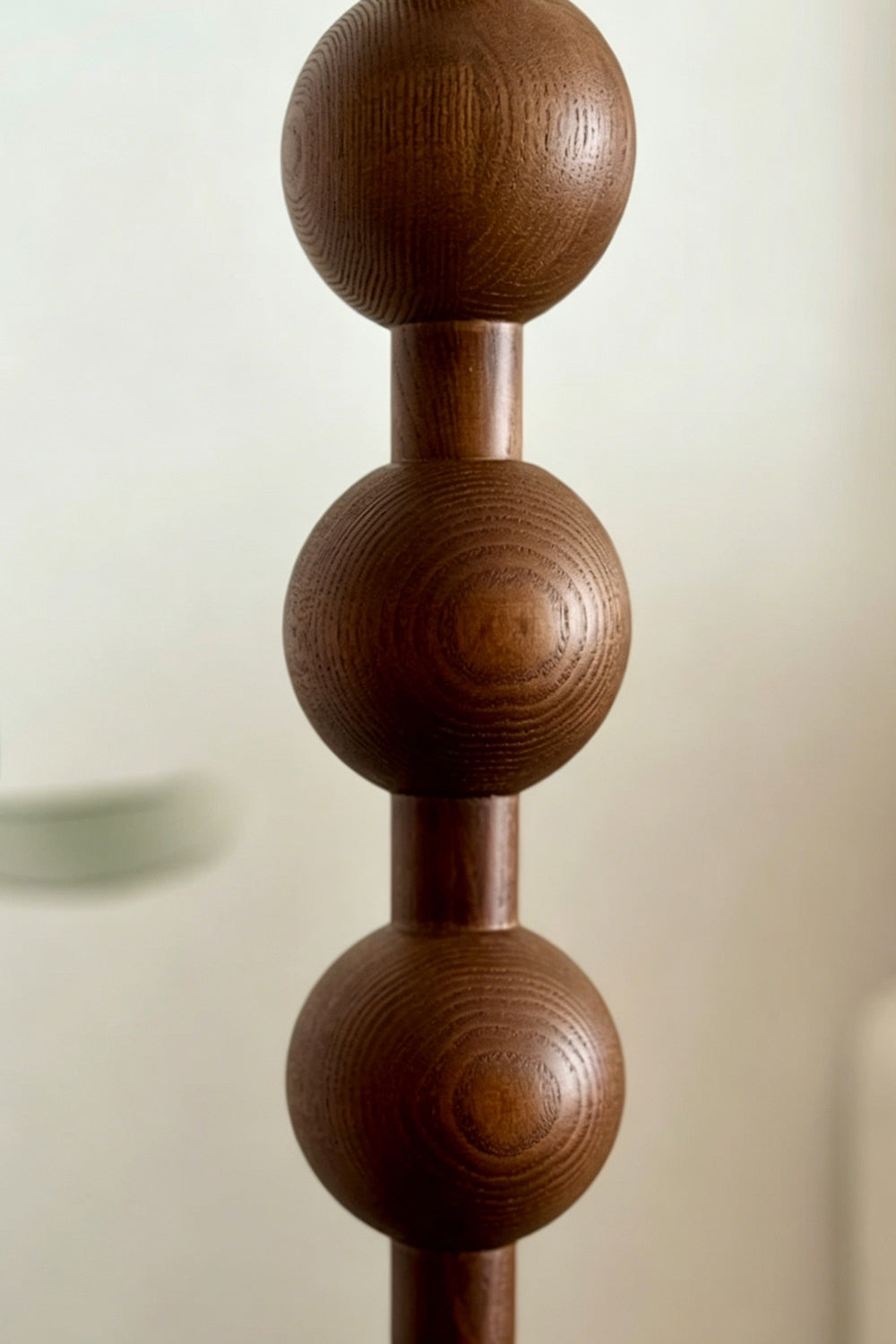 Marlow Stacked Wood Floor Lamp | Wood, Fabric | Close-up macro focus on the carved dark wood stem, showcasing the stacked spherical bobbin design and rich wood grain texture | Detail shot | vexa lamps
