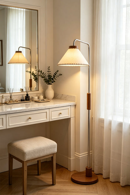 Marlowe Angled Linen Reading Floor Lamp | Linen, Wood, and Chrome Metal | Illuminating a bright makeup vanity area next to a white table with a mirror and a matching stool | vexa lamps