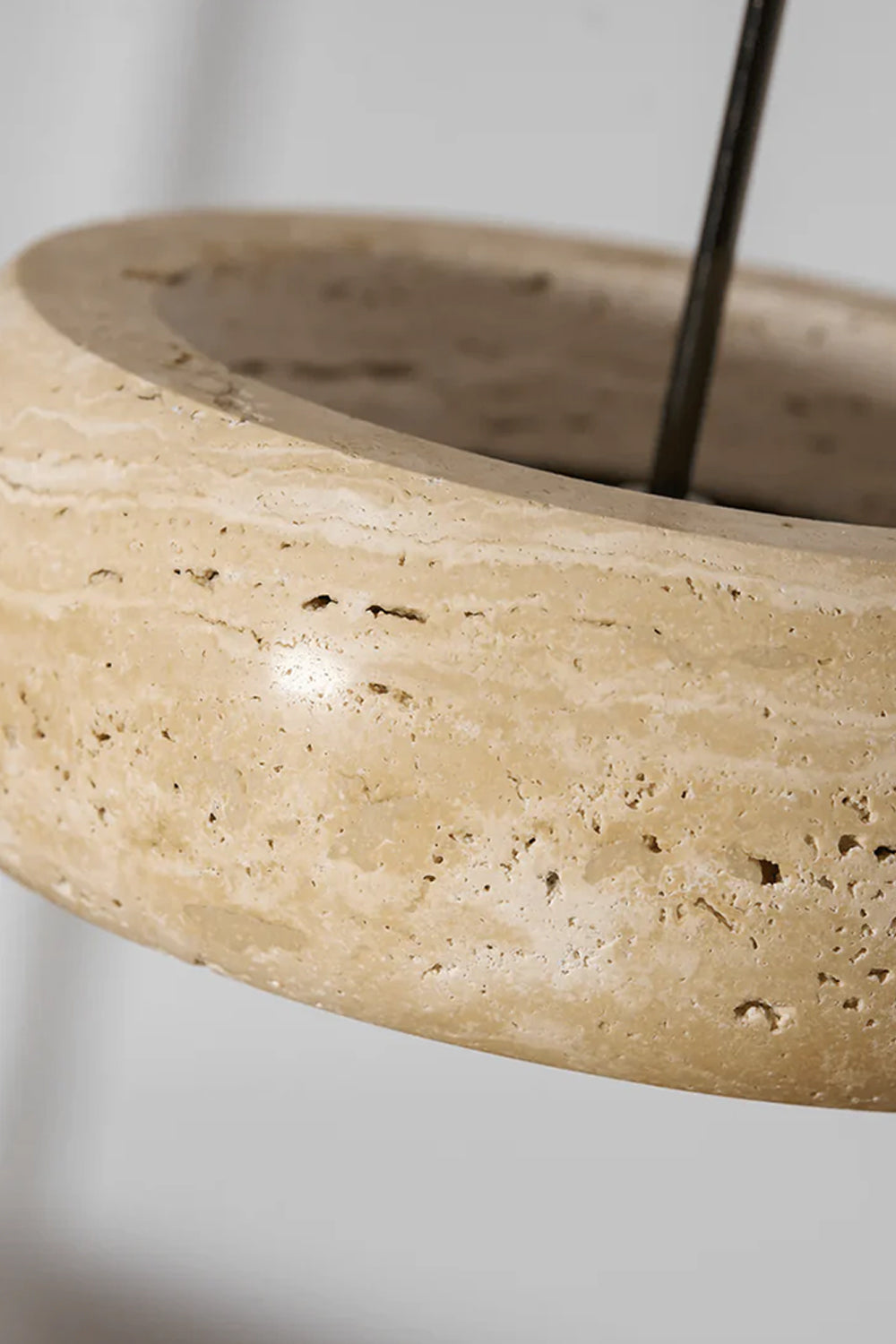 Maro Travertine Donut Pendant Light | Travertine, Metal | Close-up top angled shot of the unlit natural cream travertine stone body showcasing its organic earthy details and cord entry | Detail shot | vexa lamps