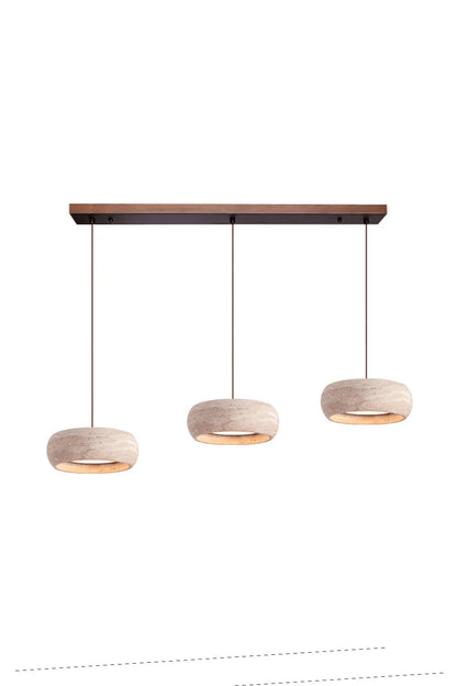 Maro Travertine Donut Pendant Light | Travertine, Metal, Wood | Studio view of the multi-light variant featuring three travertine donut shades suspended from a long dark wood rectangular canopy track | vexa lamps