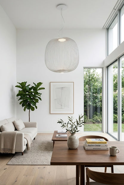 White minimalist wire cage pendant in bright living area | Aluminum | Modern interior scene with neutral decor | vexa lamps