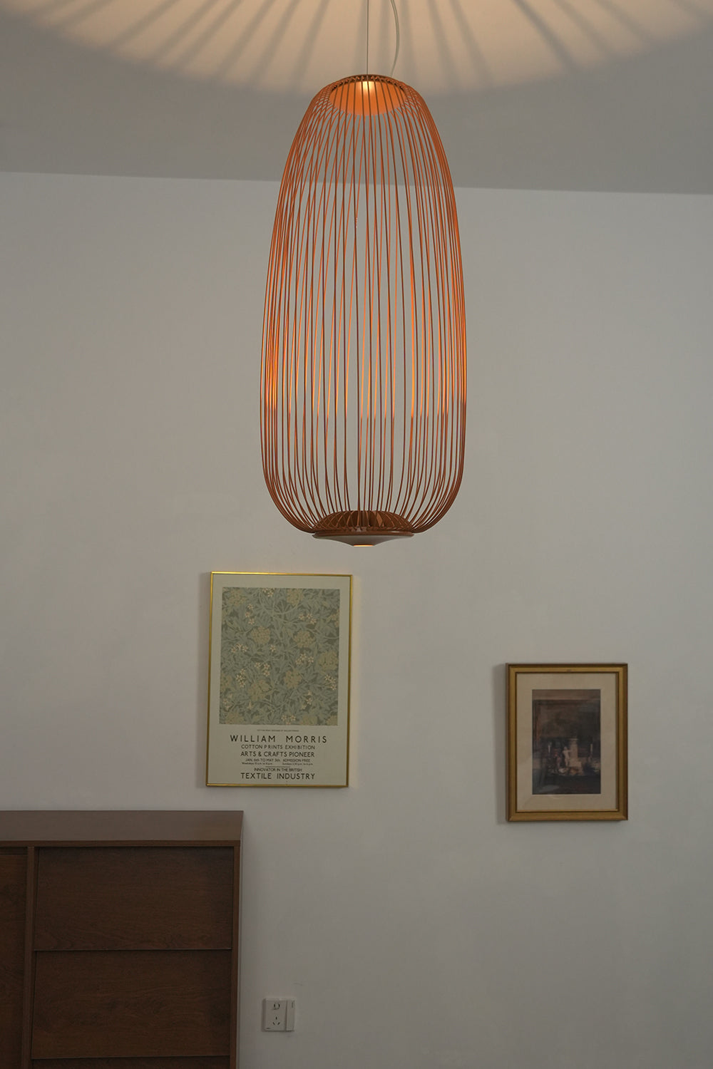 Copper elliptical wire cage pendant in hallway | Aluminum | Installed over a dark wood cabinet | vexa lamps